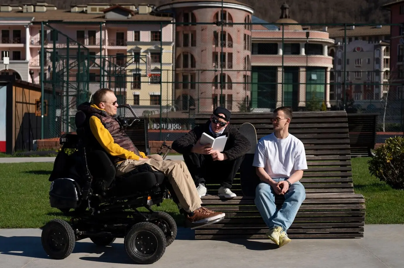 Full-body shot of a disabled man with friends outdoors.